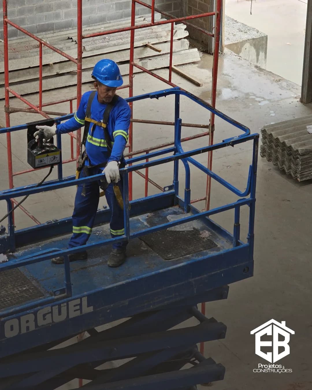 Profissional na cesta da plataforma elevatória durante serviço em altura