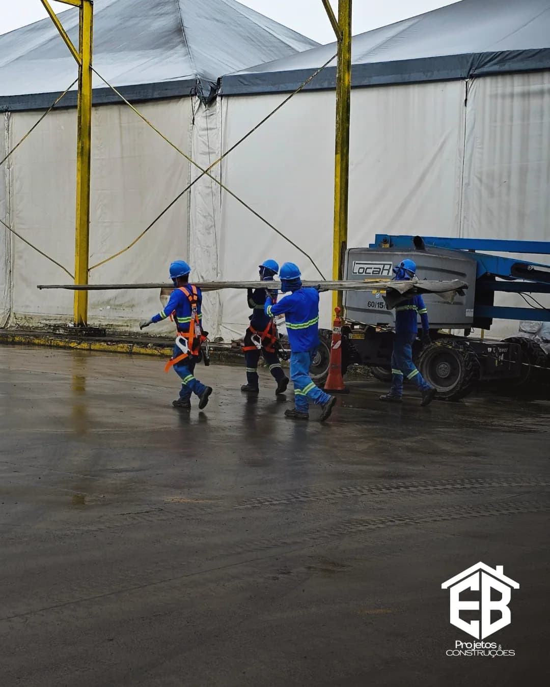 Equipe em deslocamento na área de montagem da estrutura metálica